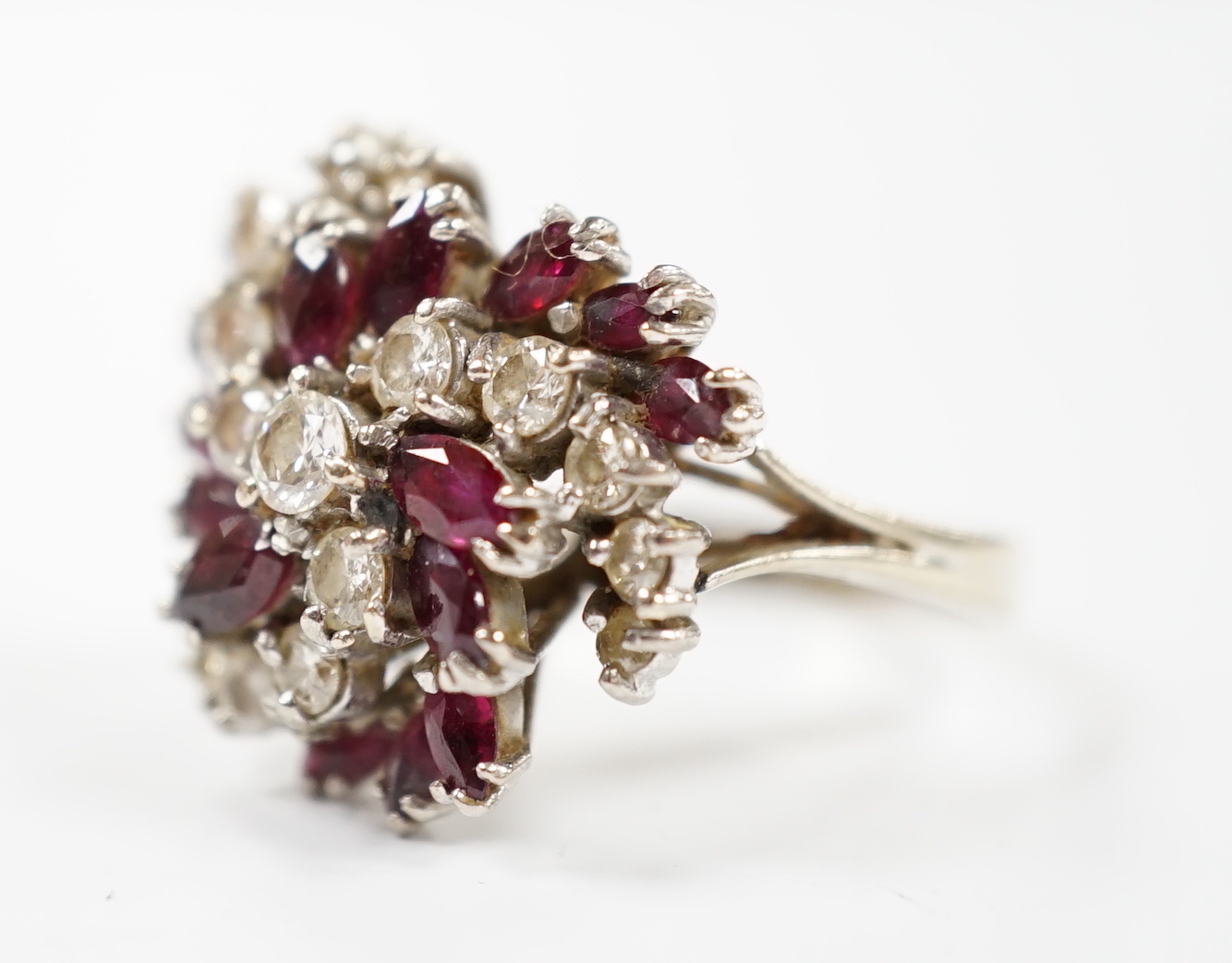 An 18ct, ruby and diamond set spiral cluster ring, size O, gross weight 7.7 grams.